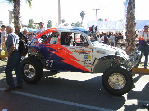 1990 Ford Bronco - Volkswagen Beetle-based Baja Bug race car, number 57, with orange and blue flame graphics, displayed at a street event.