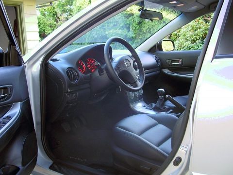 2004 Mazda 6 - The interior of a 2004 Mazda 6 features black leather seats and a dashboard with red illuminated gauges.