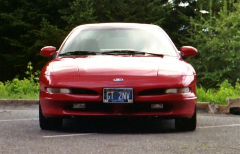 1996 Ford Probe - Red 1996 Ford Probe shown from the front in a parking lot with trees in the background.