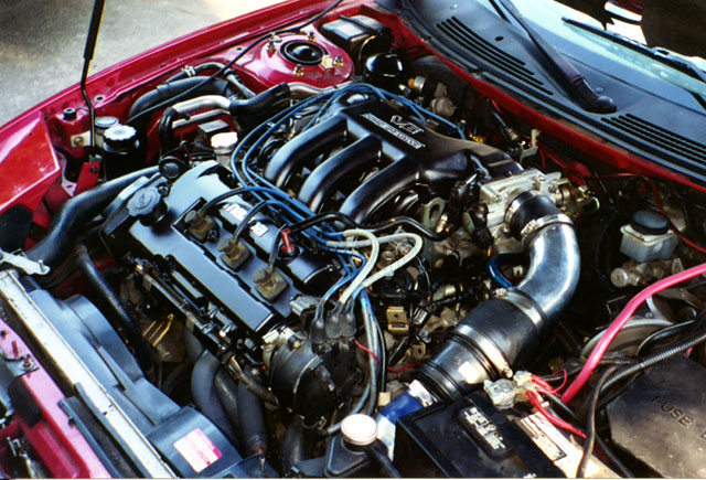 Engine bay with V6 intake manifold and red car body
