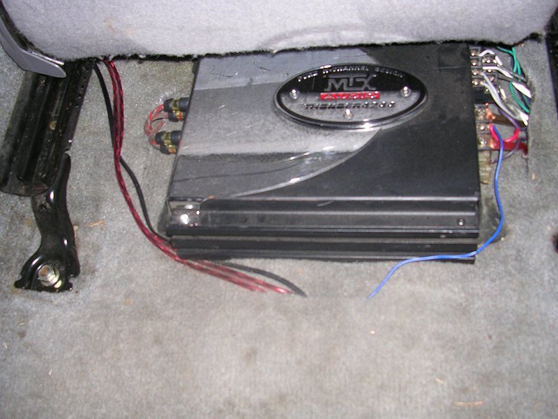 Car amplifier under a seat, with wires connected