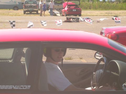 1996 Ford Probe - Driver in a red car wears a helmet and sunglasses, with "OBESNW.COM" visible on the door.