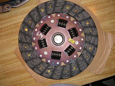 1996 Ford Probe - A clutch disc with visible springs and a yellow sticker is shown on a wooden surface.