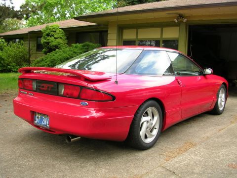 1996 Ford Probe - A red 1996 Ford Probe GT is parked in front of a garage.