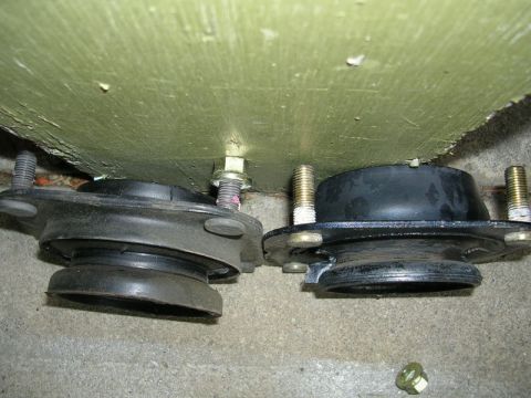 1996 Ford Probe - Comparison of two car strut mounts, possibly for replacement.