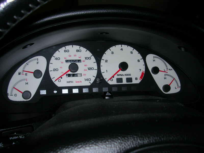 Car dashboard with speedometer, tachometer, fuel, and temperature gauges. Odometer shows 98608.4 miles