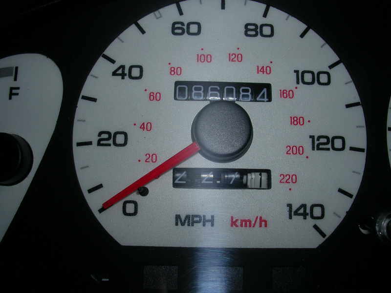 Close-up of a car's odometer showing 8608.4 miles and a fuel gauge