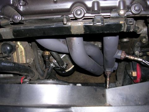 1996 Ford Probe - Close-up view of an engine's exhaust manifold and associated components.
