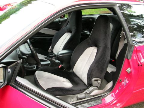 1996 Ford Probe - Interior view of a pink car with custom racing seats and a visible "PROBE" decal on the rear window.
