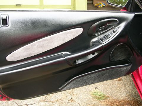1996 Ford Probe - Interior view of a car door panel, showing the handle, window controls, and speaker grille.