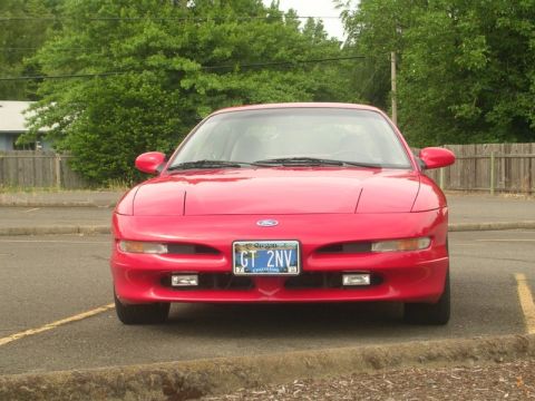 1996 Ford Probe - A red 1996 Ford Probe is shown from the front, parked outdoors with trees in the background.