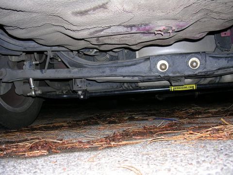 1996 Ford Probe - A view of a car's undercarriage, highlighting suspension parts and a racing component with a website address.