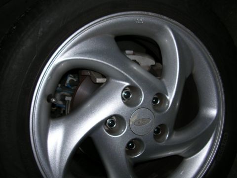 1996 Ford Probe - A close-up view of a vehicle's wheel and tire assembly, highlighting the silver alloy rim and brake components.