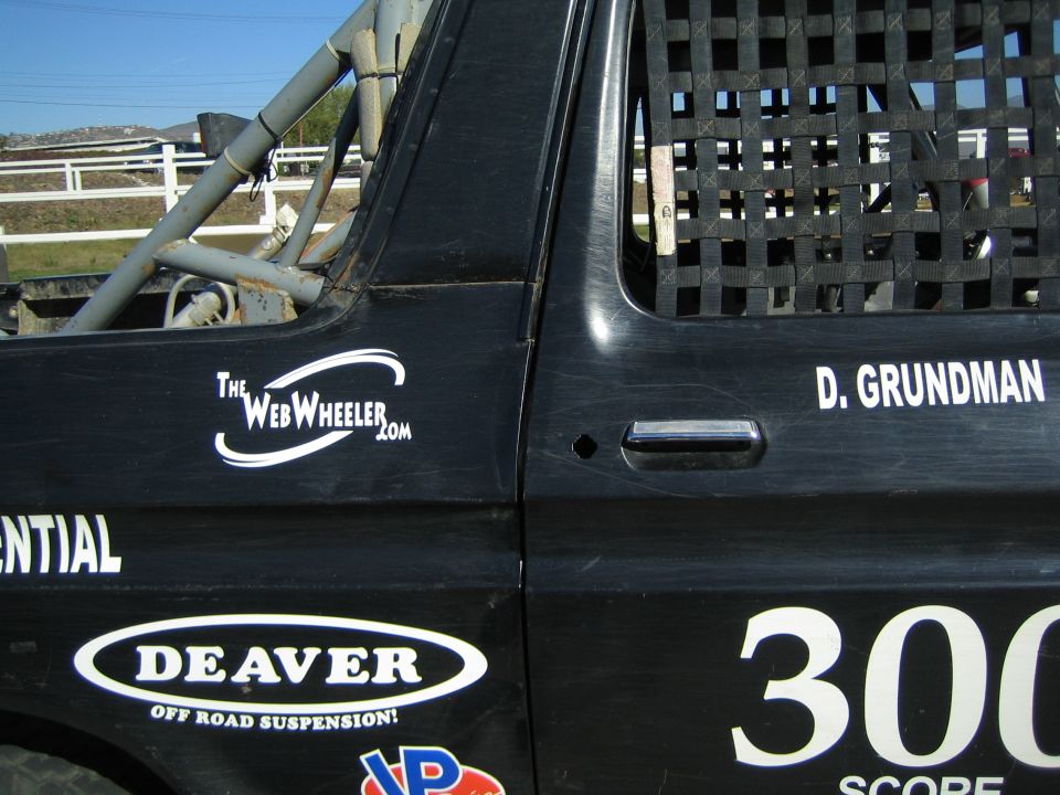 Close-up of black off-road race truck door reading D. GRUNDMAN, 300, DEAVER and TheWebWheeler.com
