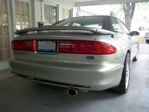 1994 Ford Probe - Rear view of a silver Ford Probe, parked under a carport with a tree in the background.