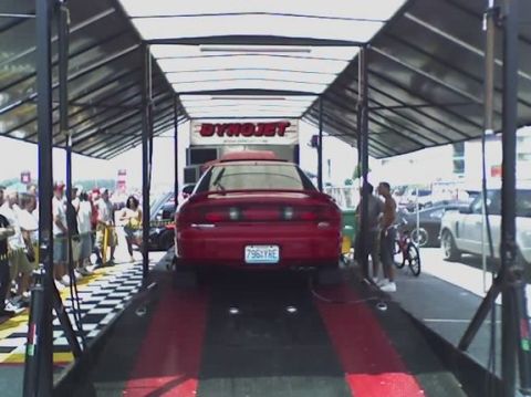 1997 Ford Probe - A red 1997 Ford Probe is positioned on a dynamometer with spectators watching.