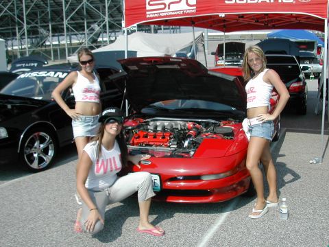 1997 Ford Probe - Three women pose with a red 1997 Ford Probe at an outdoor event.