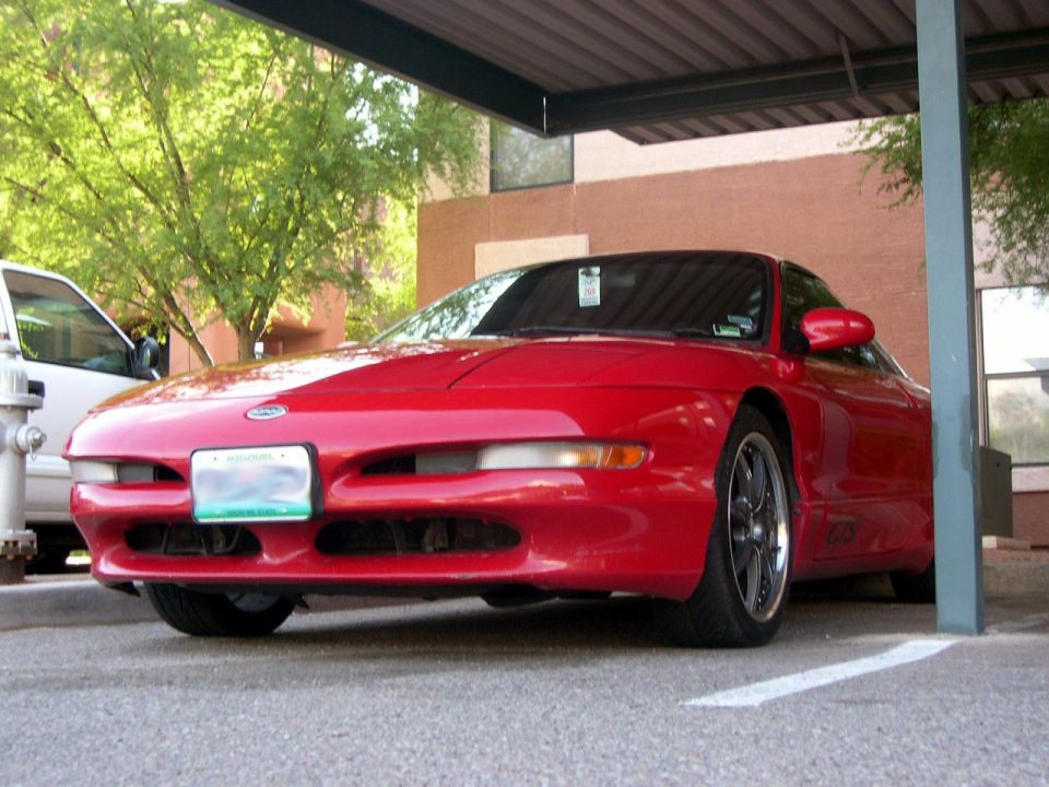 Red 1997 Ford Probe parked under a carport, 3q-front view