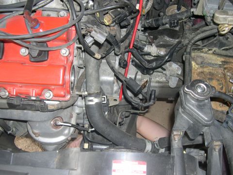 1997 Ford Probe - A mechanic's arm is visible as they work on the complex engine components of a vehicle.