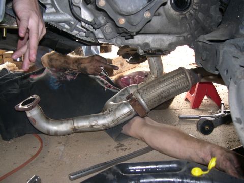 1997 Ford Probe - Mechanic performs clutch work, accessing the exhaust system from underneath the vehicle.