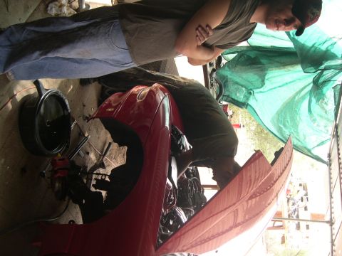 1997 Ford Probe - Mechanics work on a red 1997 Ford Probe in a garage setting.