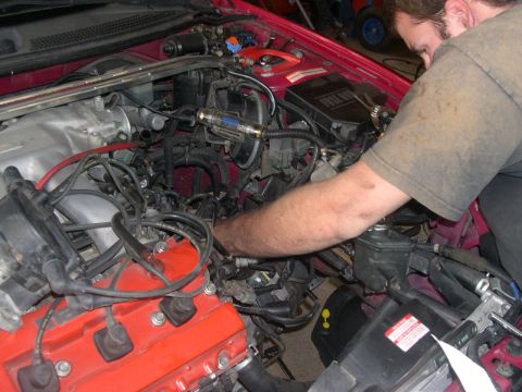 1997 Ford Probe - Mechanic performing clutch install on a 1997 Ford Probe, focusing on the engine bay components.