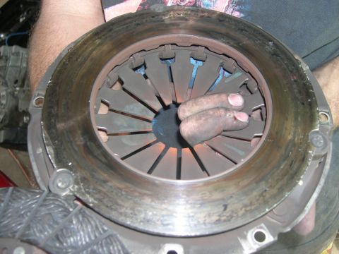 1997 Ford Probe - A worn clutch assembly is held by hands, showing signs of heavy use and potential damage.