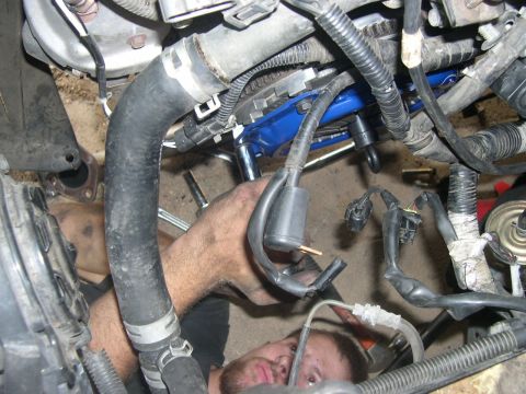 1997 Ford Probe - Mechanic is working on the engine bay of a vehicle. The SuperMotors.net logo is visible in the lower right corner.