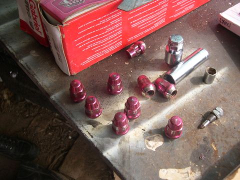 1997 Ford Probe - Lug nuts and a socket wrench are laid out on a workbench, with a red box in the background.