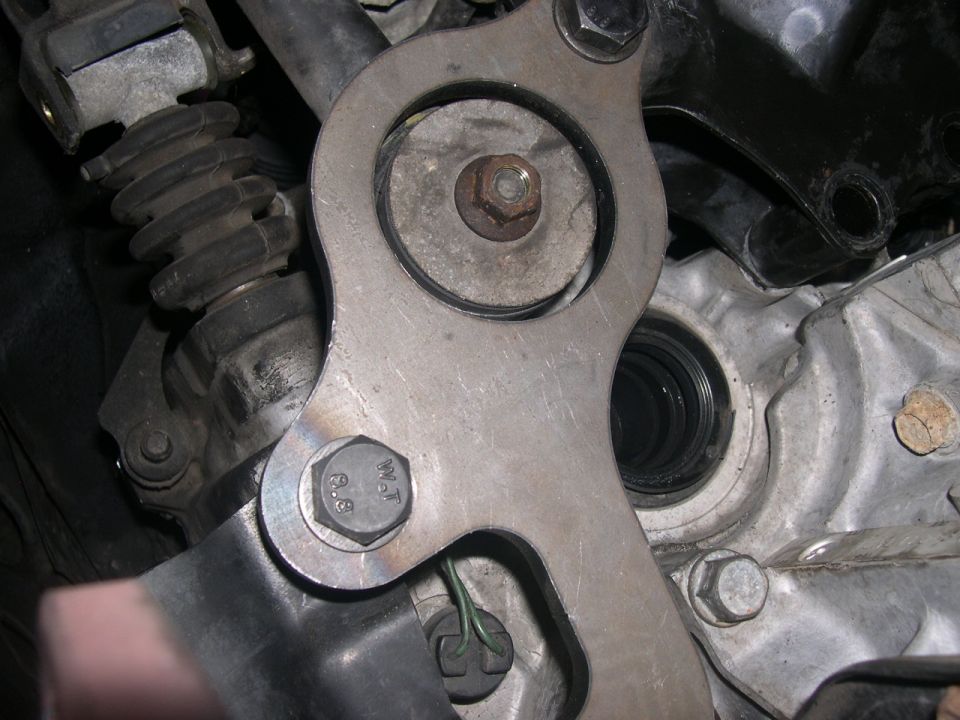 Close-up of clutch slave cylinder assembly with bolts and metal bracket