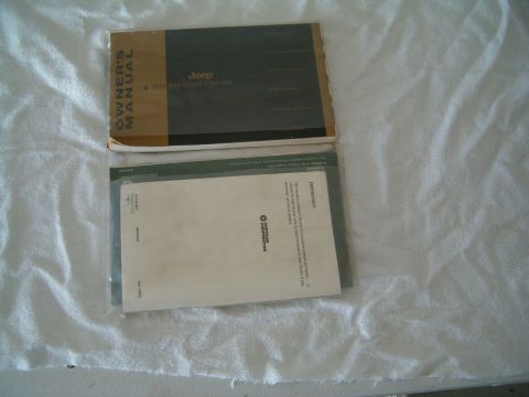 1991 Ford Bronco - Owner's manual for a Jeep and other related Chrysler Corporation documents are shown on a white cloth background.