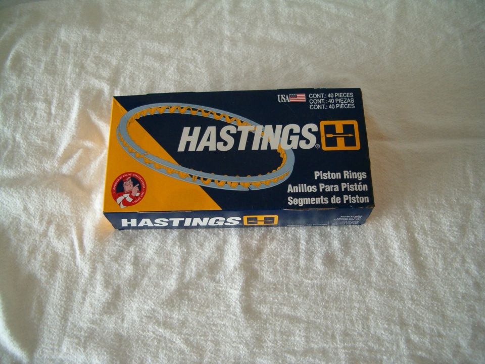 Box of Hastings piston rings with text and graphics, placed on a white textured surface