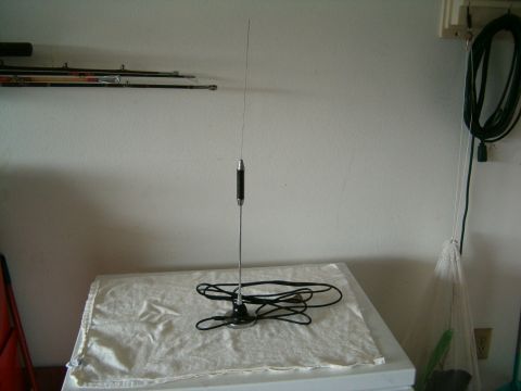 1991 Ford Bronco - A car antenna with a black base and chrome shaft is displayed on a white cloth.