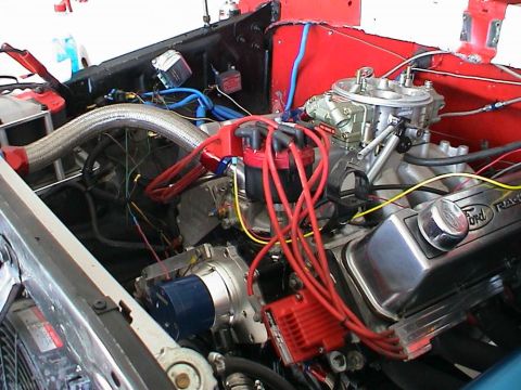1979 Ford Bronco - Close-up of a Ford V8 engine, showing the valve cover, carburetor, and ignition system components.