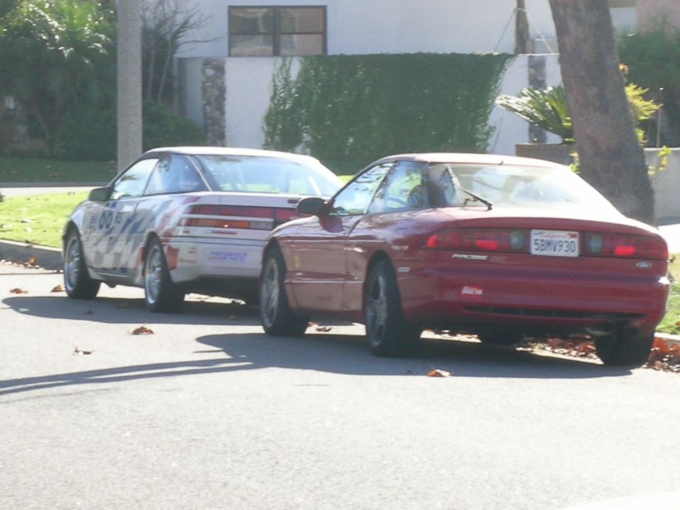 Red 1993 Ford Probe parked on street, rear view. License plate 5BMV930