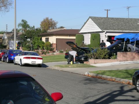 1993 Ford Probe - Several cars are parked on the street and in the driveway of a suburban home.