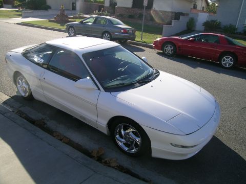 1993 Ford Probe - White 1993 Ford Probe parked on street with other cars visible in the background.