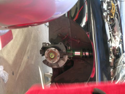 1993 Ford Probe - This image shows a close-up view of a vehicle's front suspension system, highlighting the brake rotor and shock absorber assembly.