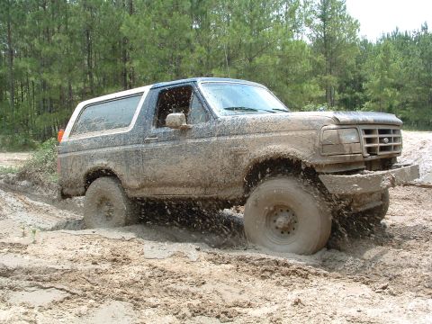 1993 Ford Bronco - This 1993 Ford Bronco is deep in the mud, showing off its off-road capabilities.