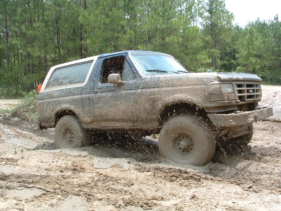 Mud-covered 1993 Ford Bronco stuck in mud, 3q-front view