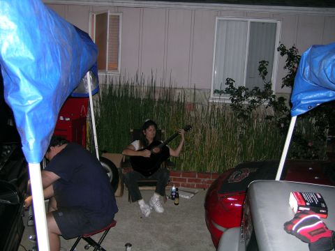 1993 Ford Probe - Backyard gathering with people and vehicles, one person playing a guitar.