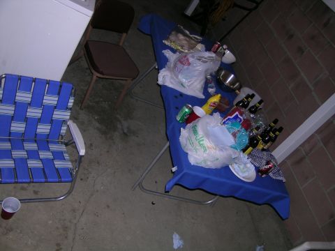 1993 Ford Probe - A table is set up with various food items, drinks, and plastic bags, suggesting a gathering or party aftermath.