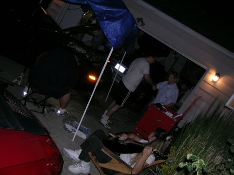 1993 Ford Probe - A group of people are seen working on a car in a garage setting, with another vehicle partially visible.