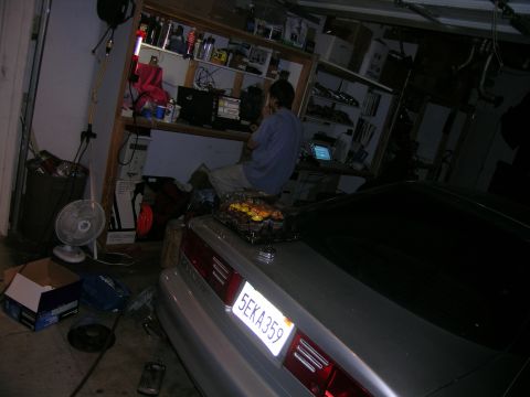 1993 Ford Probe - A silver car's rear is visible in a cluttered garage with shelves and a fan.