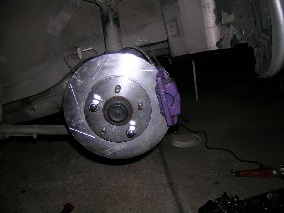 Purple brake caliper installed on a slotted rotor