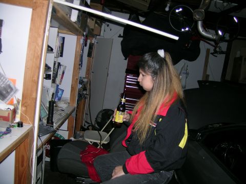 1993 Ford Probe - A woman sits in a garage holding a beer, with a car's hood visible in the foreground.