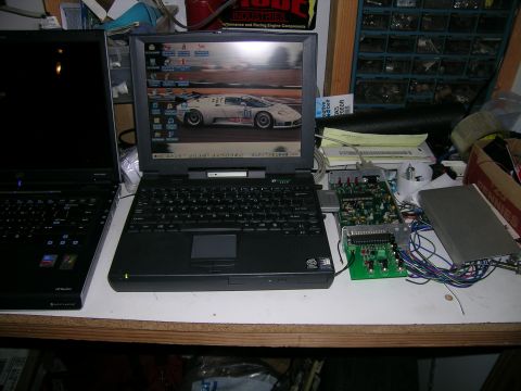 1993 Ford Probe - A laptop displays a white sports car on a race track, with other electronic components on a desk.