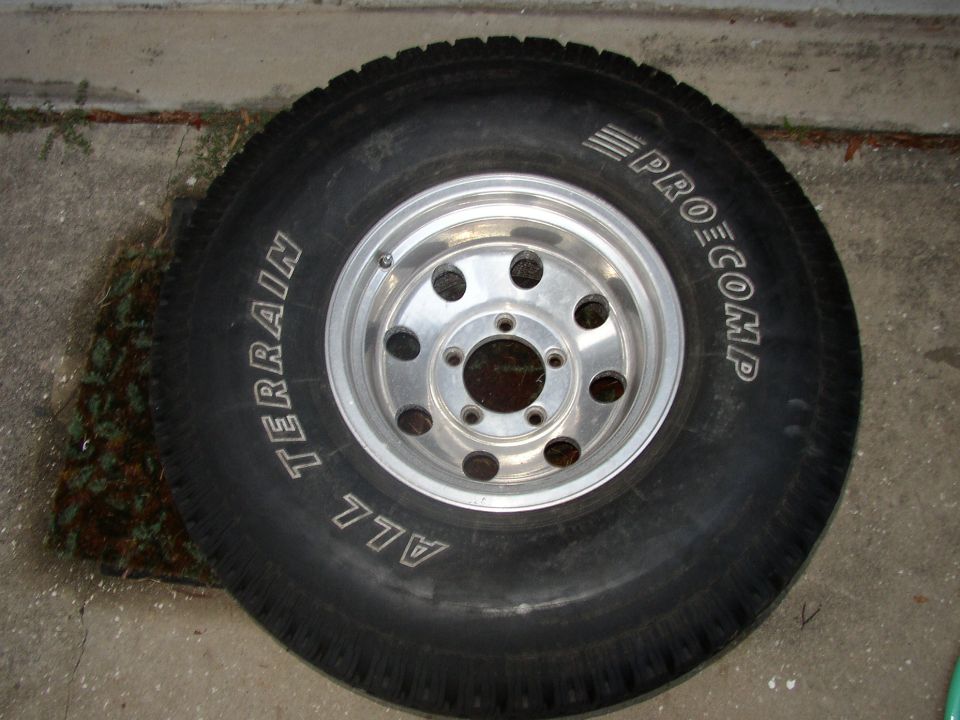 Pro Comp All Terrain tire on polished eight-hole aluminum wheel lying on concrete