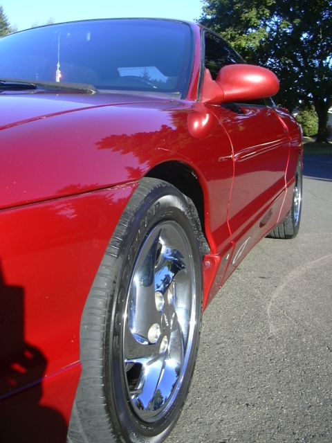 1997 Ford Probe - A red 1997 Ford Probe is shown from a 3q front angle, highlighting its side profile and chrome wheels.