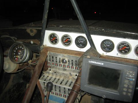 1990 Ford Bronco - Interior of a race truck showing a row of Auto Meter gauges, switch panel, shifter and a Lowrance GPS display.